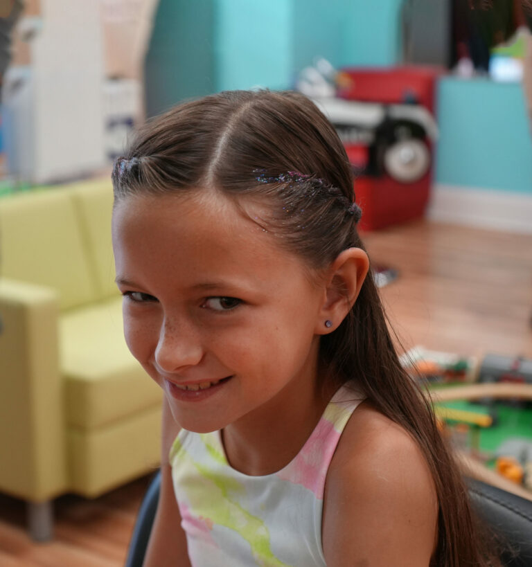 Smiling girl with glittery hair and an ear piercing - Pigtails & Crewcuts Buckhead