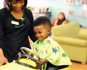 Smiling little boy and stylist - Pigtails & Crewcuts Buckhead