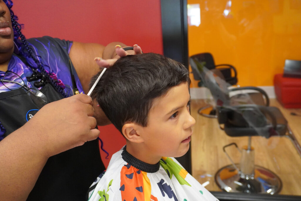 A boy with dark hair gets a fresh cut at Pigtails & Crewcuts Buckhead.