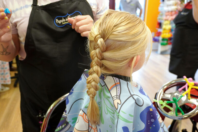 A blonde girl with a three-strand braid at Pigtails & Crewcuts Buckhead.