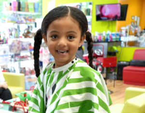 Smiling girl with braids enjoying her time at Pigtails & Crewcuts Buckhead.