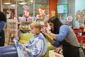 Young blonde boy getting a haircut at Pigtails & Crewcuts in Buckhead.