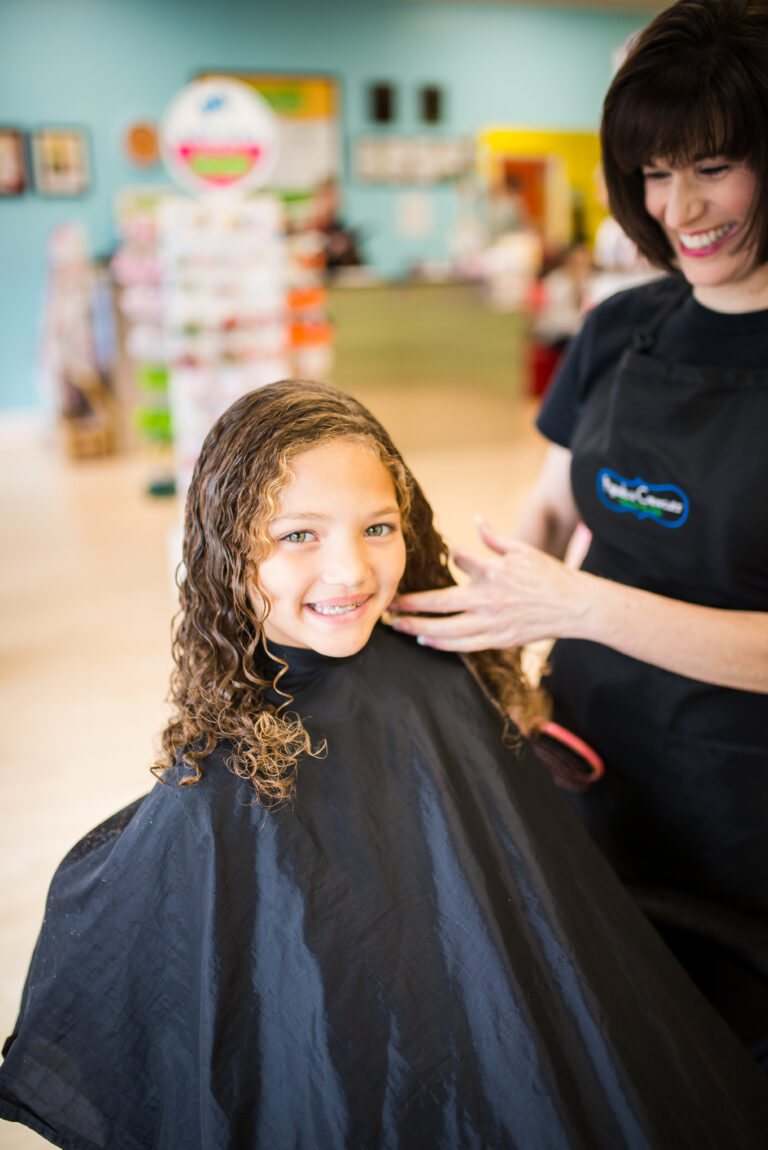 Girl getting her hair brushed - Pigtails & Crewcuts Smyrna