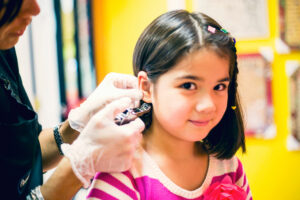 Girl getting her ear pierced - Pigtails & Crewcuts Smyrna/Vinings