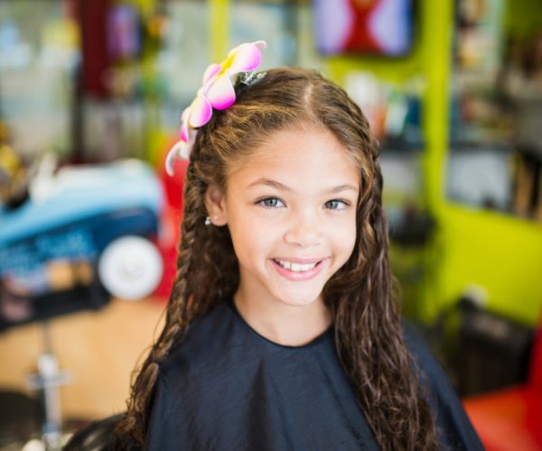 Smiling girl with flower in her hair - Pigtails & Crewcuts Smyrna/Vinings