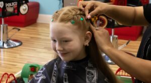 Girl getting a braid and hair jewels at Pigtails & Crewcuts Greenville Augusta Road