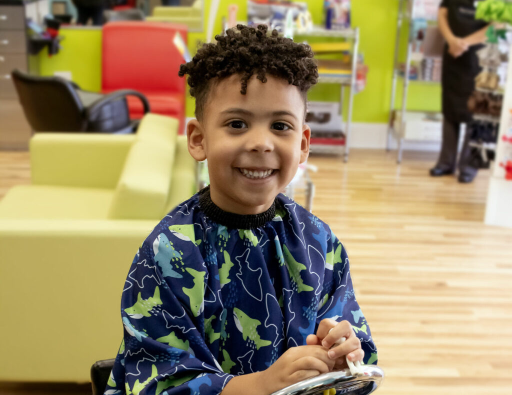 Boy with curly top haircut at Pigtails & Crewcuts