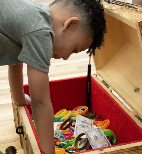 Boy checking out the treasure chest at Pigtails & Crewcuts Jacksonville