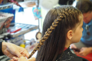 Girl getting her hair braided - Pigtails & Crewcuts Jacksonville