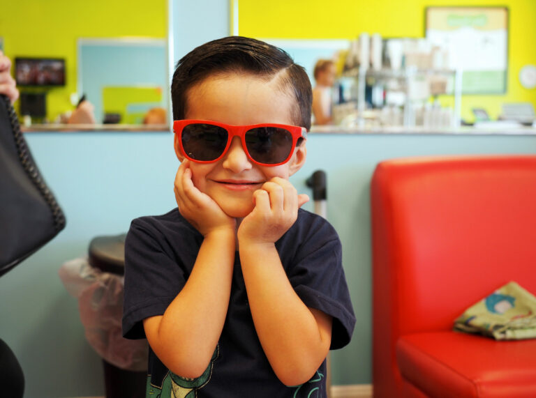 Boy in red sunglasses smiling at camera - Pigtails & Crewcuts Jacksonville