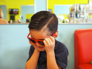 Boy in red sunglasses smiling - Pigtails & Crewcuts Jacksonville