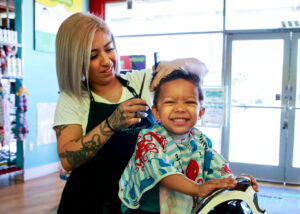 Smiling boy gets his hair cut in the salon - Pigtails & Crewcuts Jacksonville