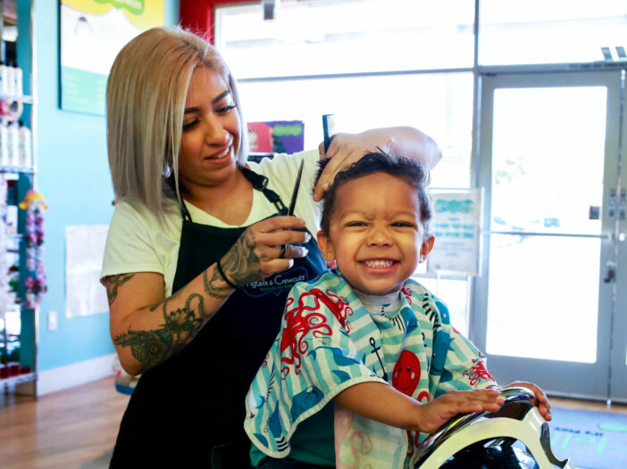 Smiling boy gets his hair cut in the salon - Pigtails & Crewcuts Jacksonville