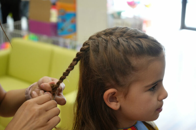 Girl getting her hair braided in the salon - Pigtails & Crewcuts Jacksonville