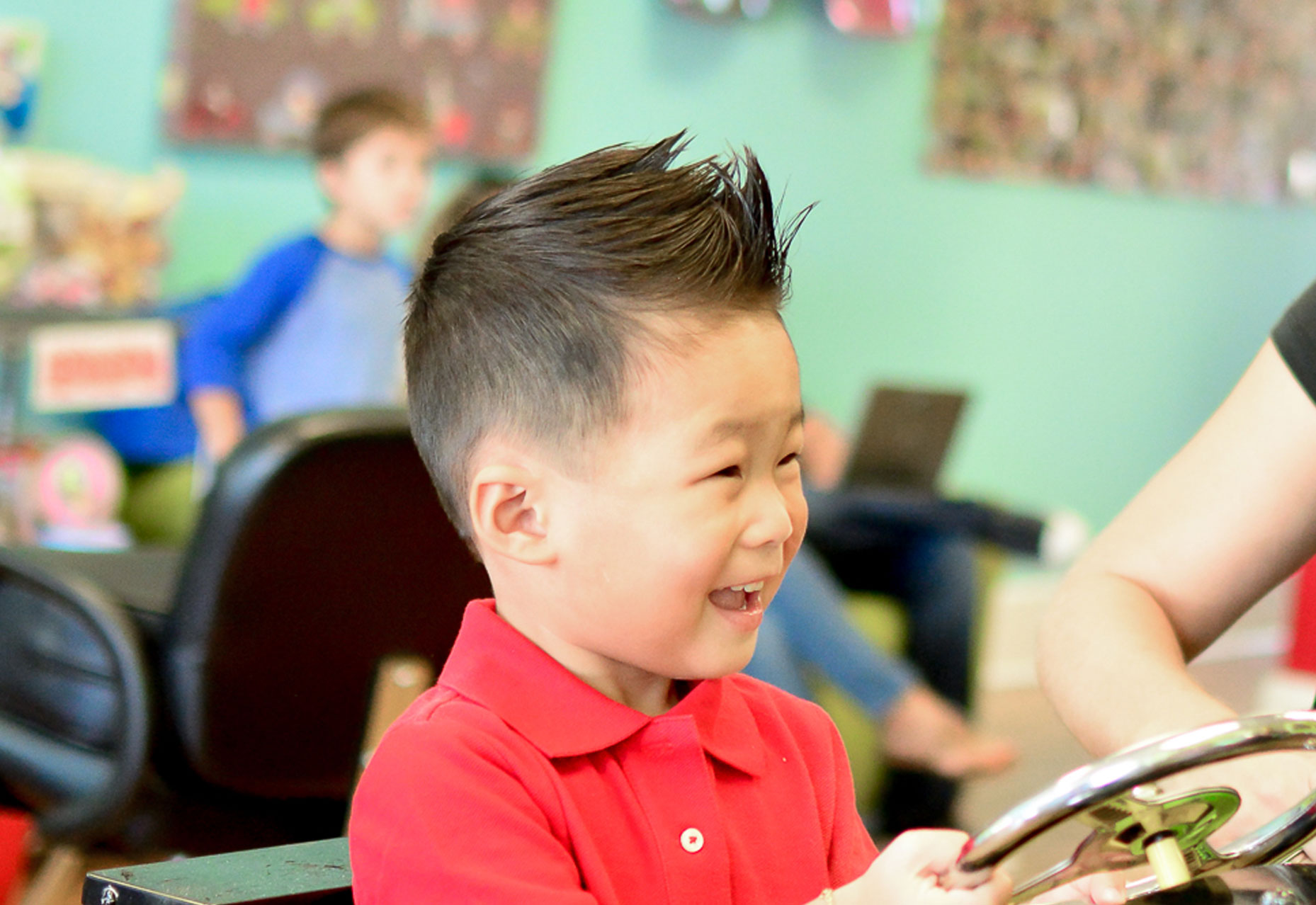 LIttle asian boy smiling after a great haircut