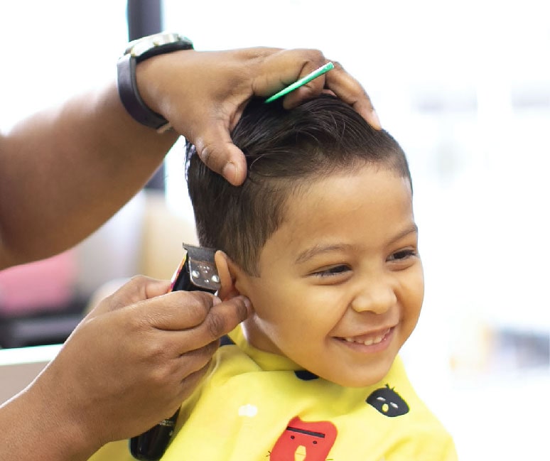 Little boy getting a hair trim at Pigtails & Crewcuts