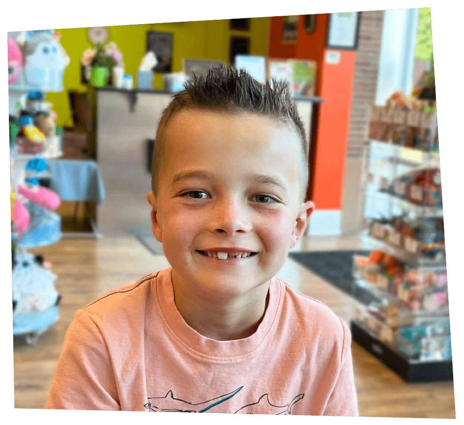 Smiling boy with a Back to School haircut from Pigtails & Crewcuts