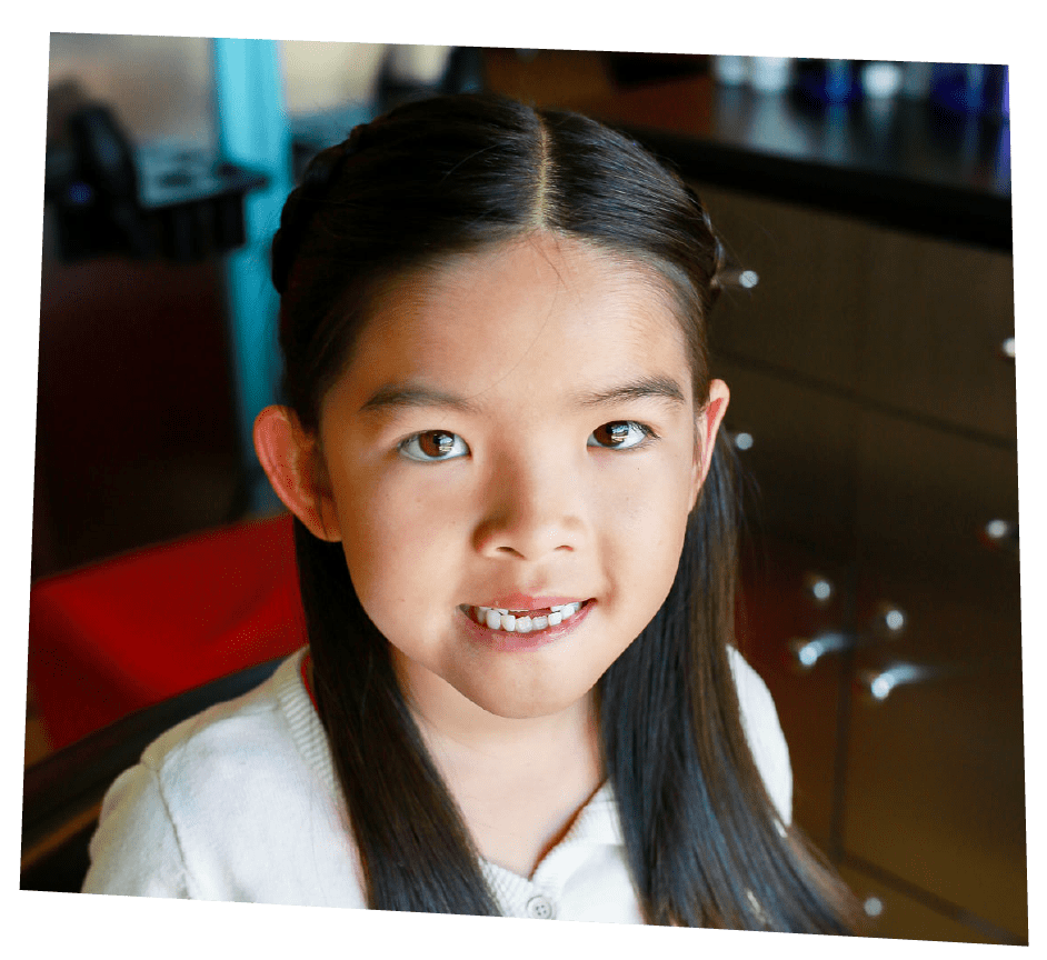 Smiling girl with a Back to School haircut from Pigtails & Crewcuts