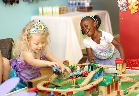 Girls playing at the train table at Pigtails & Crewcuts