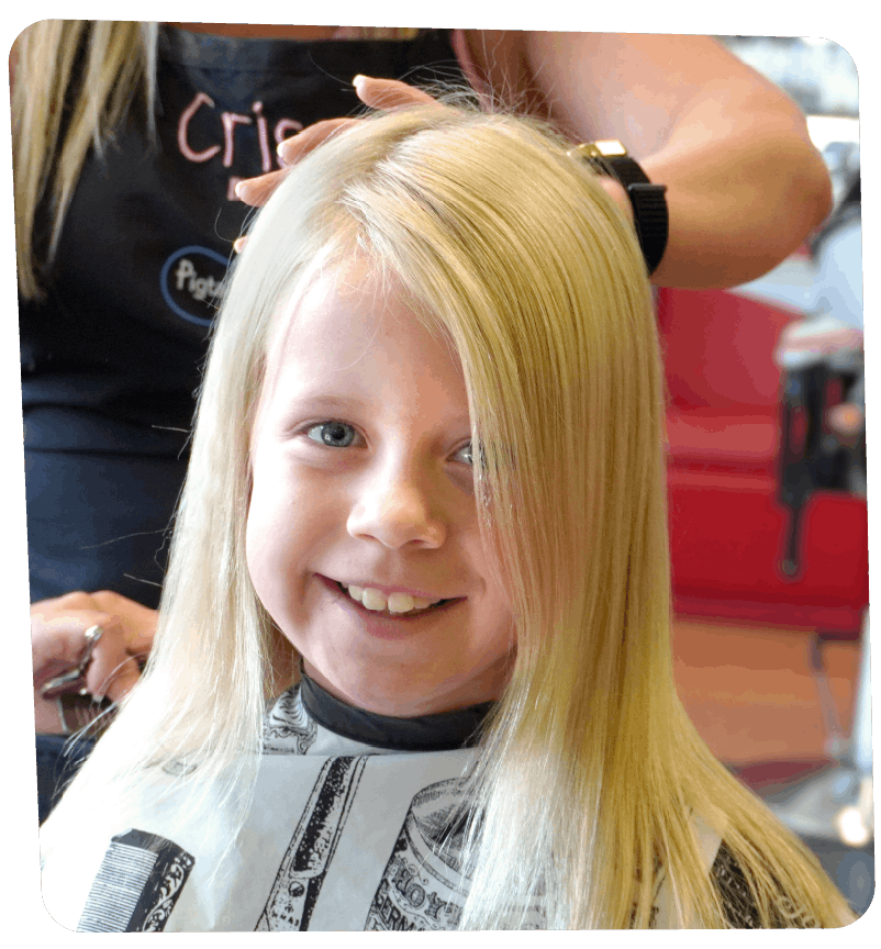 Smiling girl getting her Back to School haircut at Pigtails & Crewcuts