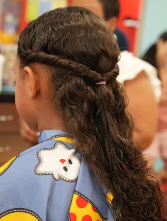Young girl with braided, natural curls at Pigtails & Crewcuts